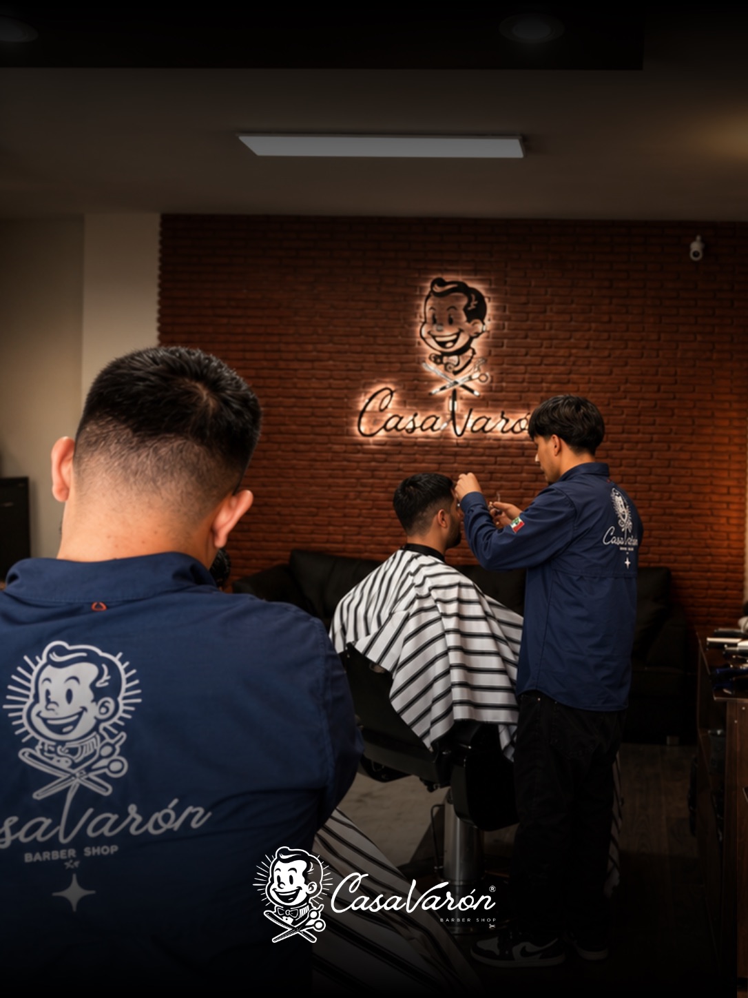 Los barberos de Casa Varón frente a la pared de neón